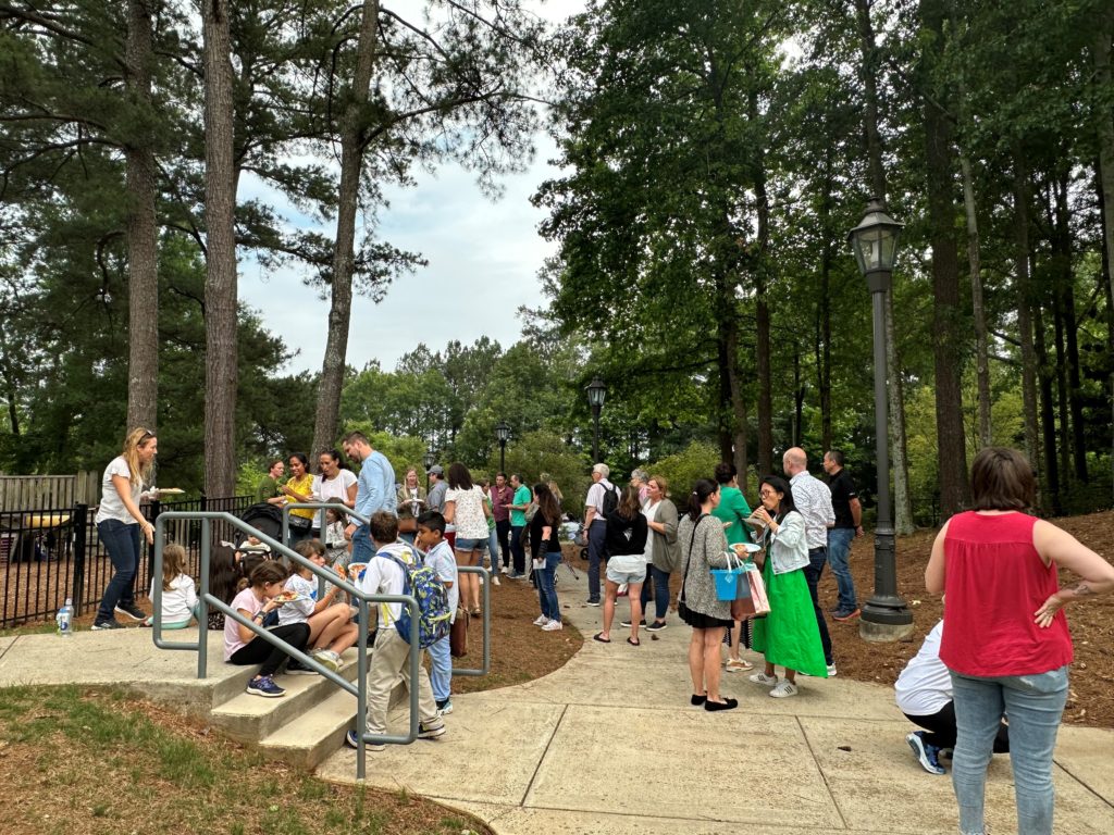 Children outside waiting to be picked up by their parents on the last day of school